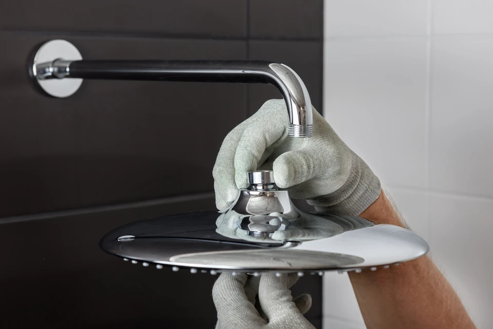 Plombier professionnel installant un robinet de lavabo dans une salle de bains moderne