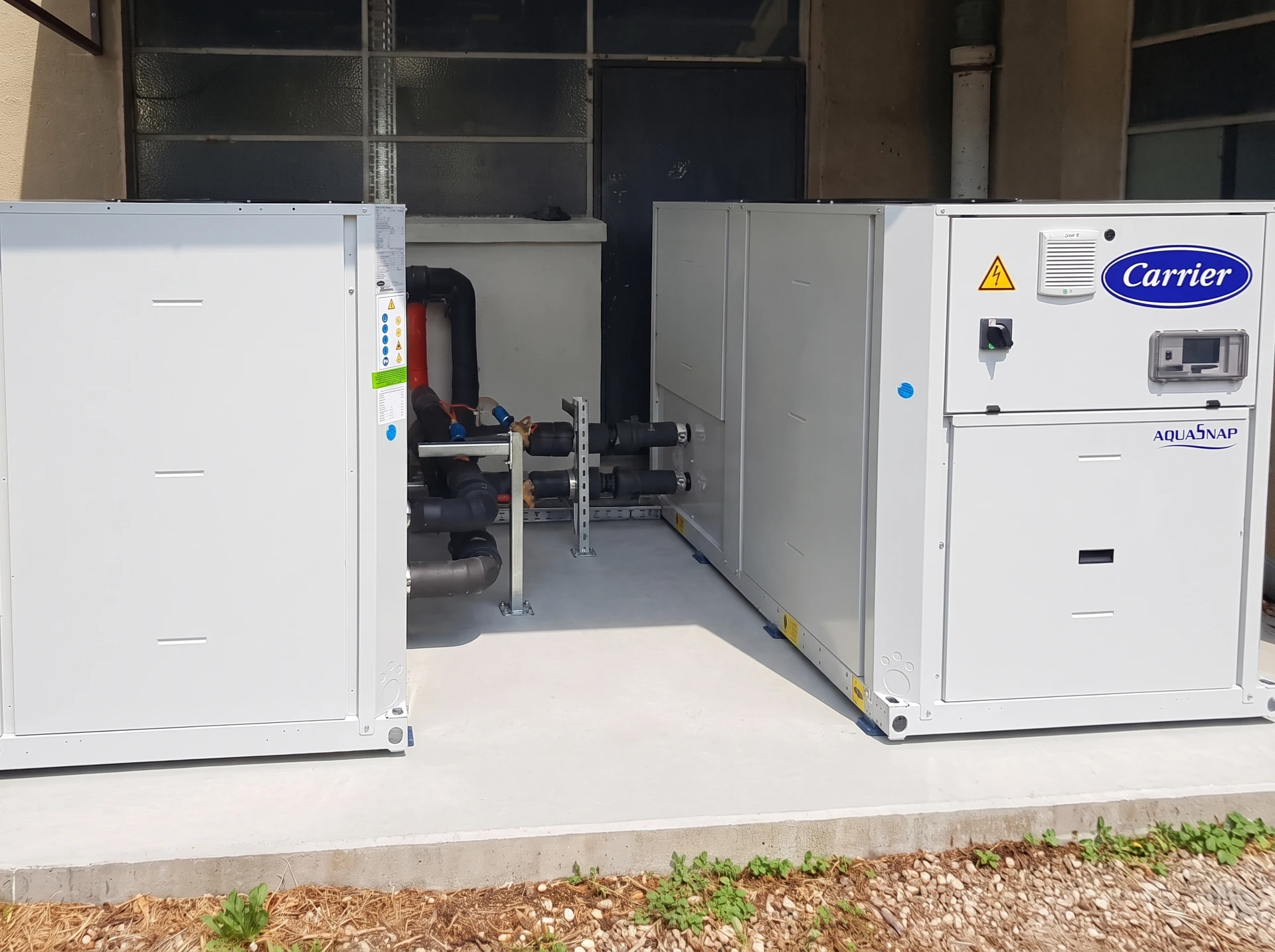 Ouvrier en combinaison bleue et casque blanc installant un radiateur chauffage central dans une pièce en rénovation