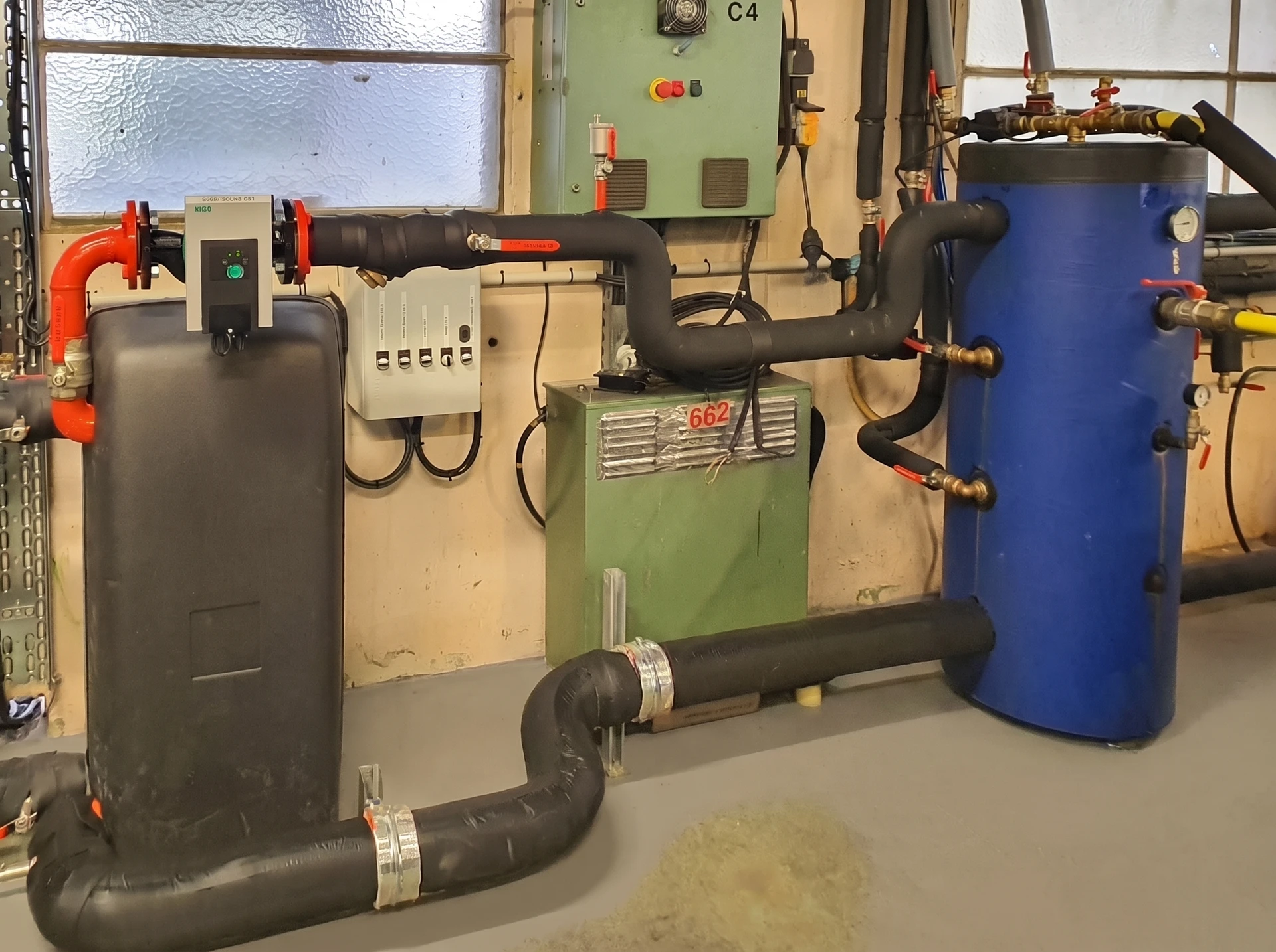 Plombier professionnel intervenant sur chauffe-eau domestique, utilisant un multimètre pour diagnostic électrique