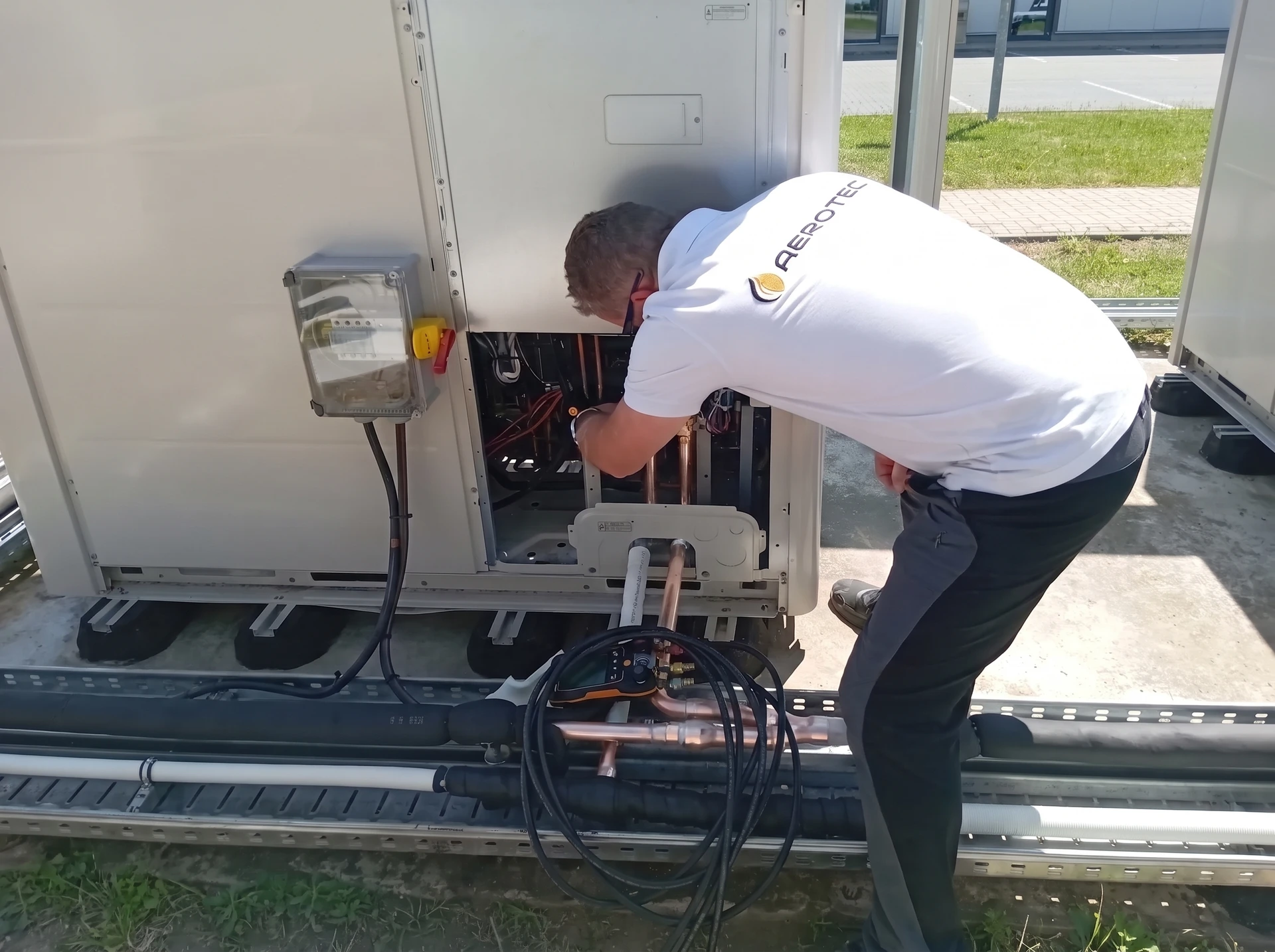 Intérieur résidentiel, technicien en gants bleus effectuant maintenance d'une unité de climatisation murale